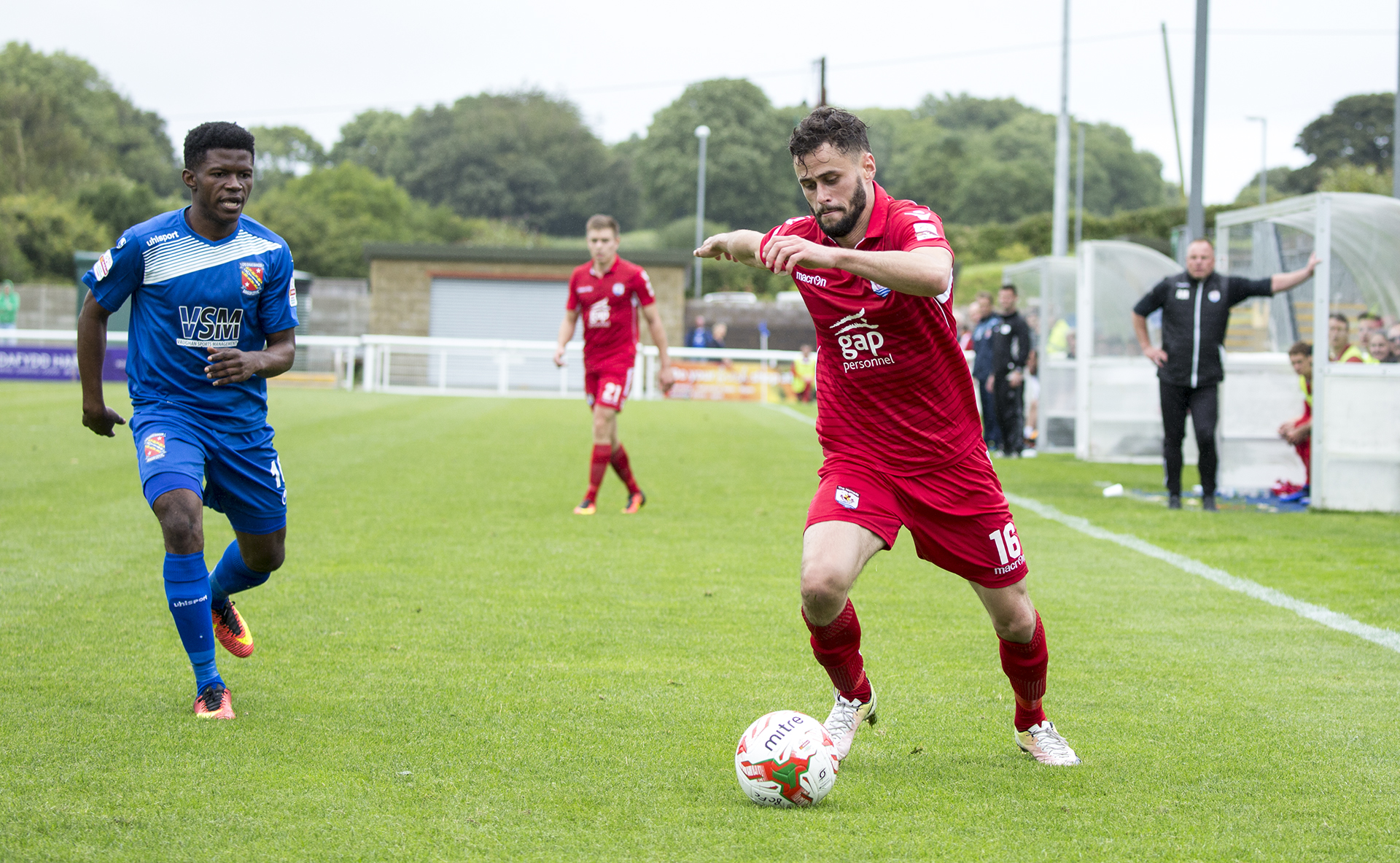 Nathan Woolfe takes on the Bangor City defence - © NCM Media