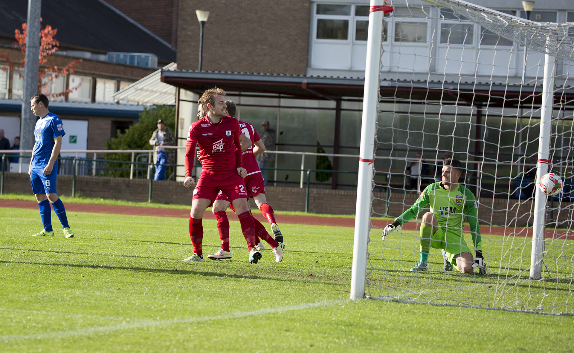 John Disney celebrates as River Humphreys' flick goes beyond Connor Roberts in the Bangor goal - © NCM Media