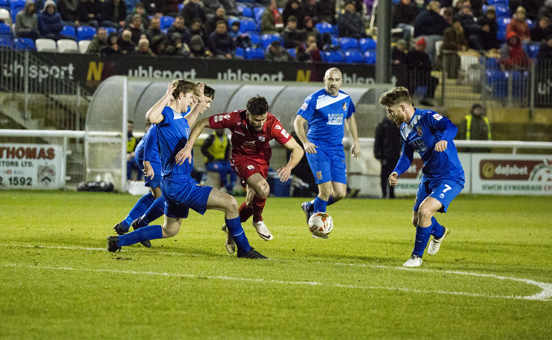 Nathan Woolfe is challenged by Bangor's defence - © NCM Media