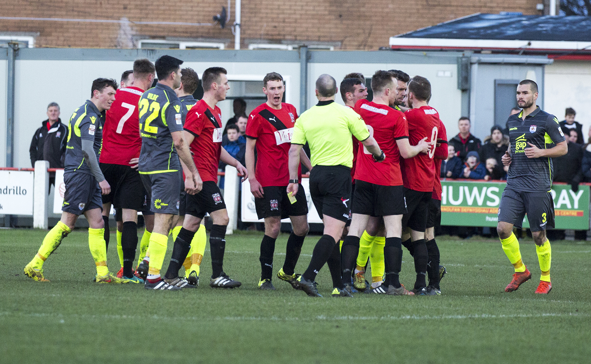 Tempers flare following a challenge which saw Danny Harrison booked for The Nomads - © NCM Media