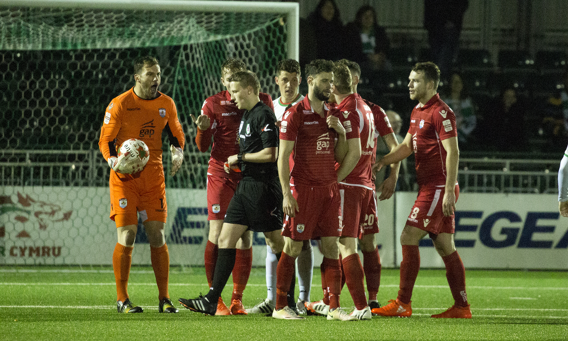 The Nomads' players react angrily as Nathan Woolfe is shown a straight red card