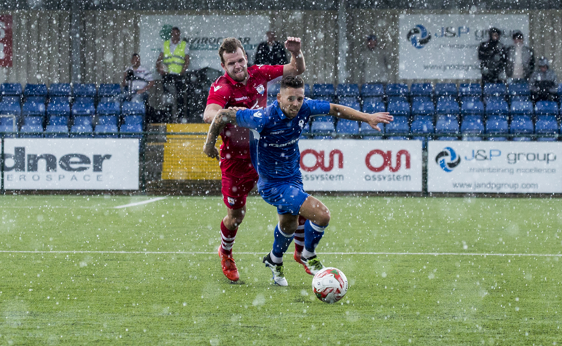 Ex-Nomads Wes Baynes and Callum Morris clash as they battle through the inclement weather - © NCM Media