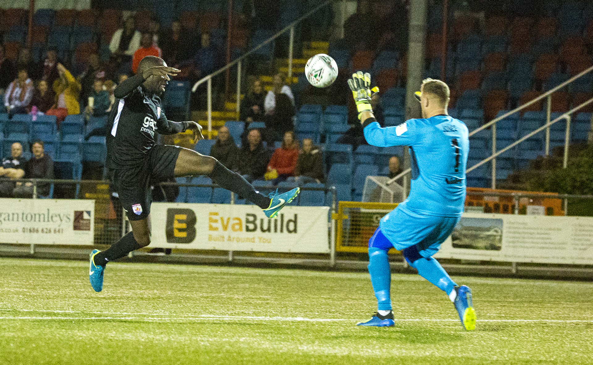 Michael Bakare dinks the ball over Dave Jones in the Newtown goal en route to his equaliser | © NCM Media