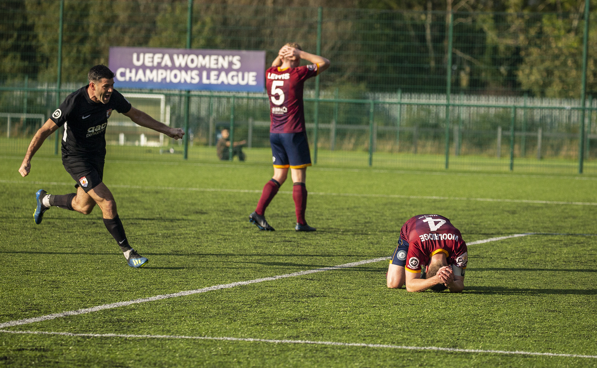 Michael Wilde celebrates as a dejected Bradley Woolridge lies on the floor having headed into his own net | © NCM Media