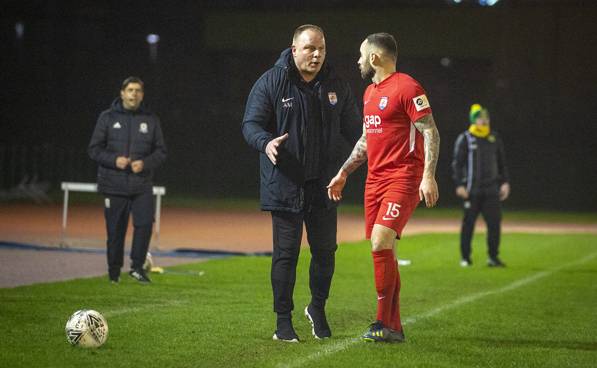 Andy Morrison and Danny Holmes talk during a match at Deeside Stadium | © NCM Media